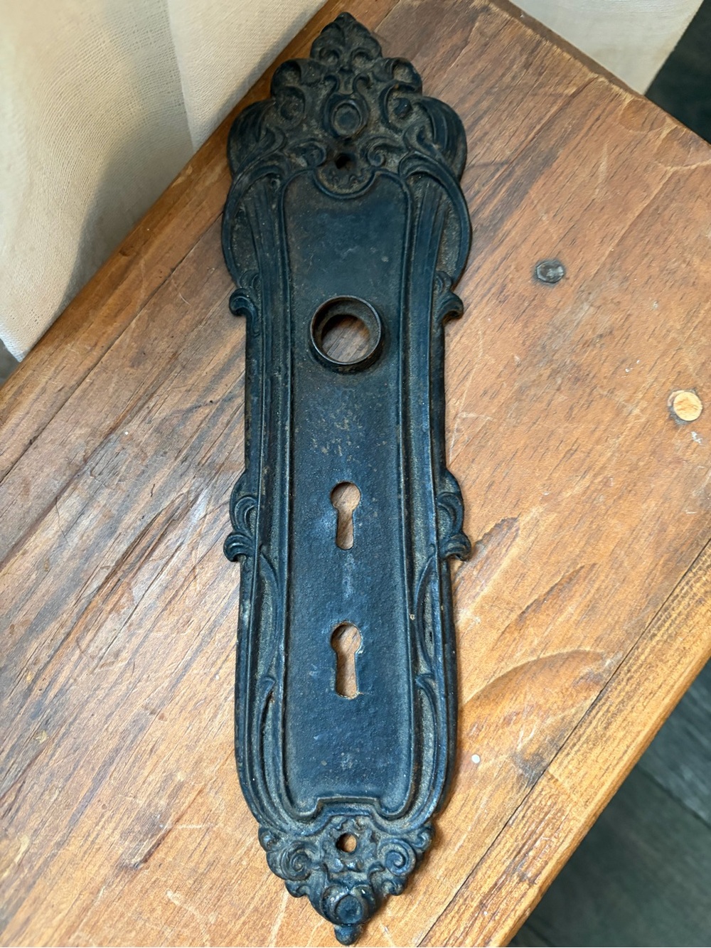 Antique Ornate cast iron door backplate with a dark finish